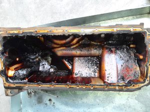 BMW 530i F10 - sump with oil sludge and carbonised deposits & debris at GP Motor Works